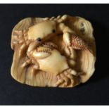 A signed mammoth ivory netsuke of two crabs with a fish