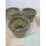 A set of three small concrete garden pots