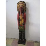 A carved wooden tobacco store Native American in traditional dress with detachable tomahawk,