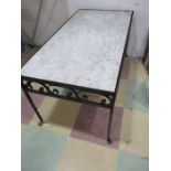 A marble topped coffee table on wrought iron base