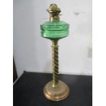 A Victorian brass oil lamp with green glass font