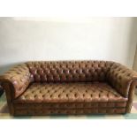 A brown leather button backed chesterfield sofa