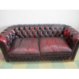 A red leather button backed chesterfield sofa