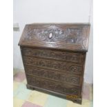 A turn of the century heavily carved oak bureau