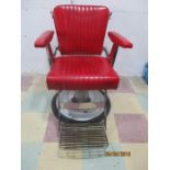 A vintage Belmont barbers chair with adjustable head rest, original red vinyl covering
