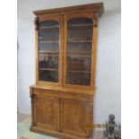 A tall Victorian display cabinet with cupboard under