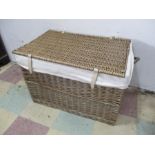 A wicker laundry basket with linen lining