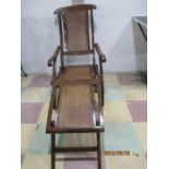 A stained steamer chair with cane seating