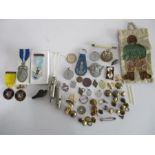 A collection of military badges, buttons, whistles, German badge etc