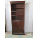 A tall Victorian bookcase with cupboard under