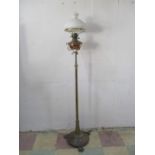 A brass Victorian floor standing adjustable oil lamp