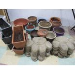 A collection of garden pots and troughs along with concrete stepping stones in the form of paw