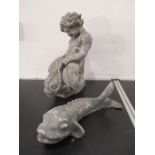 A lead water feature in the form of a mer child riding a stylised dolphin along with one other