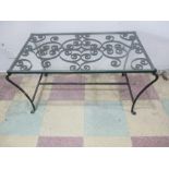 A glass topped wrought iron coffee table