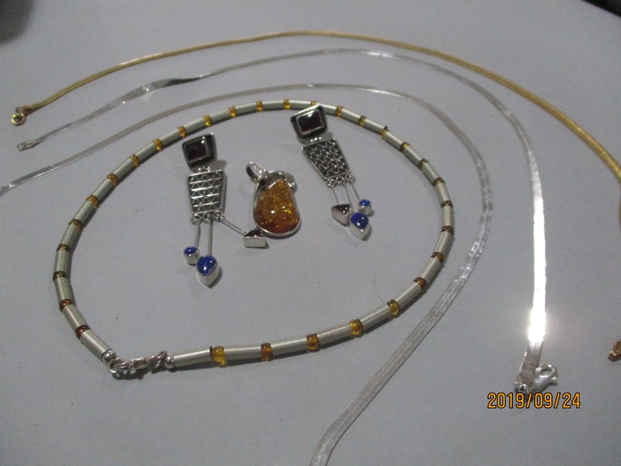 Three 925 silver necklaces along with one other, amber silver pendant and a pair of earrings.