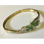 A 9ct gold hinged bracelet with a floral design including diamonds. Total weight 10.9g