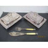 A pair of silver plated entree dishes along with a pair of fish servers