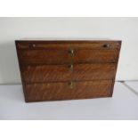 A small oak three drawer chest with small slide drawer