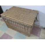 A wicker laundry basket with rope handles