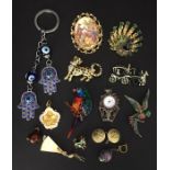 A collection of costume jewellery including various brooches and a 1950 L*A*M*D*A medallion.