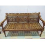 A teak bench with carved decoration