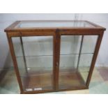 A vintage oak shop display cabinet with two doors