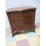 A small serpentine front chest of three drawers with brush slide