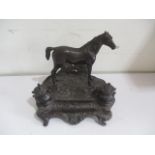 A bronze inkwell with pen tray surmounted with a horse