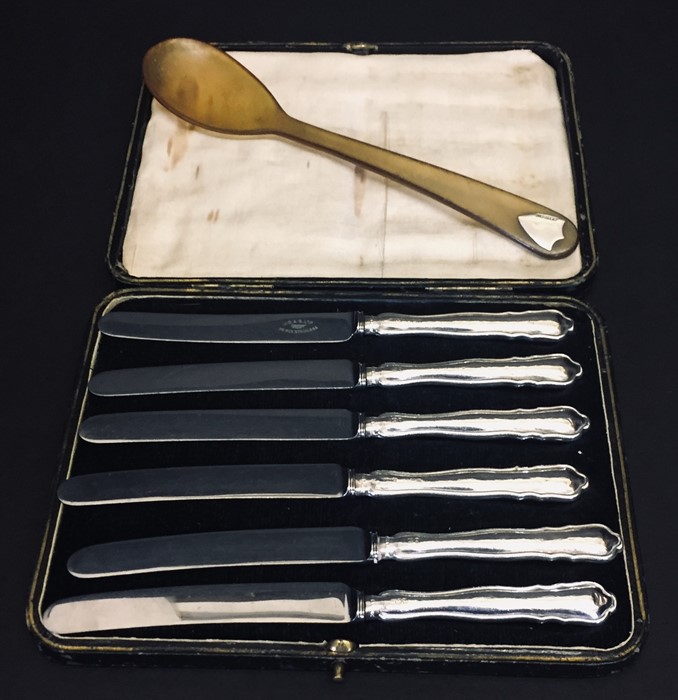 A set of silver handled fruit knives along with a horn spoon inset with silver.