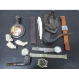 A collection of various items including pipes, watches, razors etc