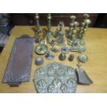A collection of various brass items including candlesticks, along with a copper tray.