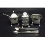 A hallmarked silver condiment set along with a small pair of silver nips.