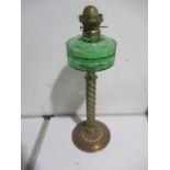A Victorian oil lamp with green glass font