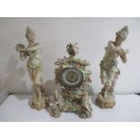 A turn of the century floral encrusted clock along with a large pair of bisque figures- some losses