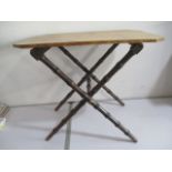 A pine topped folding table with faux bamboo legs