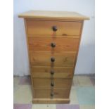 A narrow pine chest of six drawers