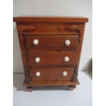 A miniature pine chest of drawers with lift up lid