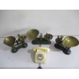 A collection of three vintage weighing scales with brass weights, along with a telephone