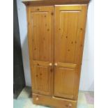 A pine wardrobe with drawer under