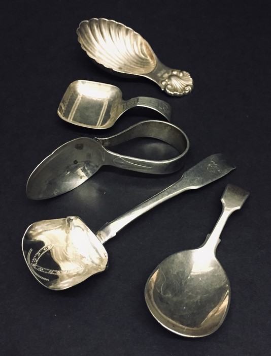 Four hallmarked silver caddy spoons along with a silver feeding spoon.