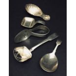 Four hallmarked silver caddy spoons along with a silver feeding spoon.