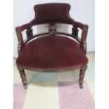 An Edwardian upholstered tub chair on turned legs