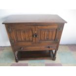 A oak cupboard with draw under and linen fold decoration