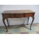 An Edwardian serpentine fronted side table with three drawers