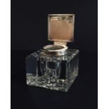 A silver hallmarked inkwell in cut glass mount.