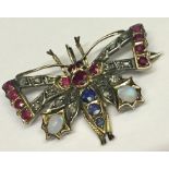 A Victorian brooch in the form of a butterfly set with diamonds, rubies, sapphires and opals in an