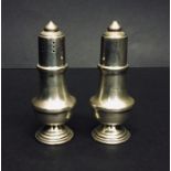 A cased pair of hallmarked silver salt and pepper shakers.