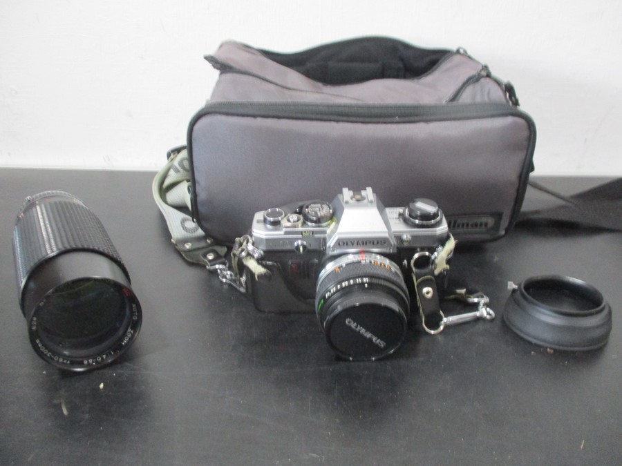 An Olympus OM10 camera along with Sirius 60-300mm zoom lens etc