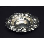 A sterling silver bon bon dish decorated with leaves and berries.