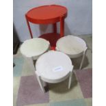 A 1970's occasional table in orange along with a set of three similar small stacking versions